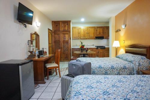 a hotel room with two beds and a kitchen at Hotel Las Fuentes in Los Mochis