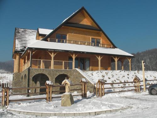 a log cabin in the snow with a fence at Willa Grywałd in Grywałd
