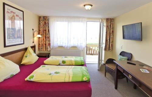ein Hotelzimmer mit 2 Betten und einem Schreibtisch in der Unterkunft Gasthof Alter Felsenkeller in Naumburg