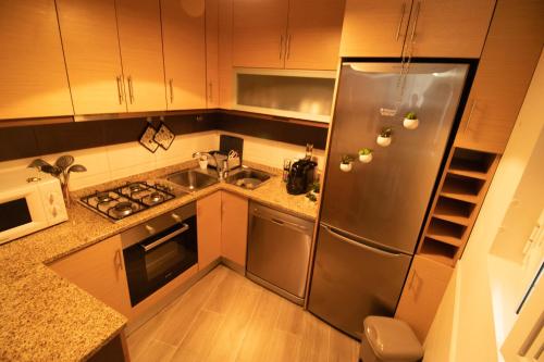 uma cozinha com um frigorífico de aço inoxidável e um lavatório em CASA DA AVÓ ZIRINHA em Viseu