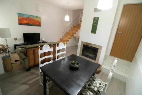 a living room with a table and a fireplace at CASA DA AVÓ ZIRINHA in Viseu