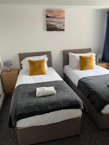 a bedroom with two beds with yellow pillows at Wymington House in Bedford