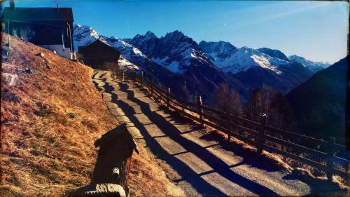 a shadow of a fence on a hill with mountains at s Lois Schönes Studio im ruhigen Kaunertal in Kaunertal