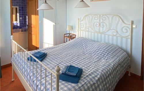 a white bed with a blue and white checkered blanket at 6 Bedroom Awesome Home In Entrecasteaux in Entrecasteaux