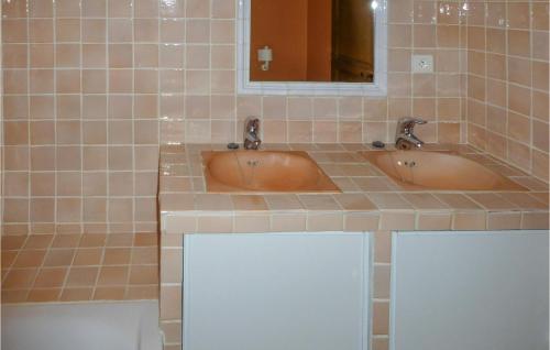 two sinks in a tiled bathroom with a mirror at 6 Bedroom Awesome Home In Entrecasteaux in Entrecasteaux