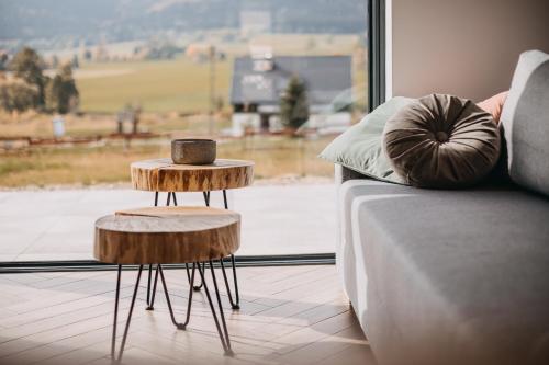a couch with two end tables next to a window at Lasosfera Lasówka in Lasowka