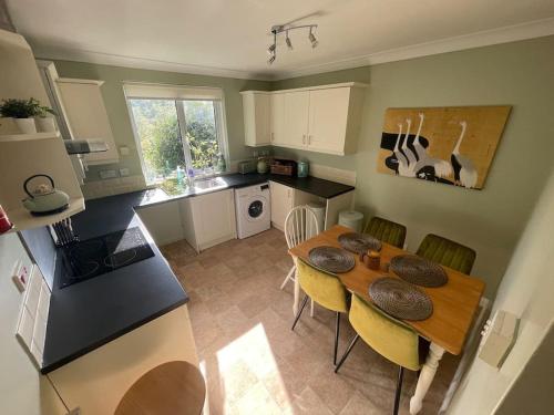 a kitchen and dining room with a table and chairs at Secluded 3 bed cottage in private parkland in Brockenhurst