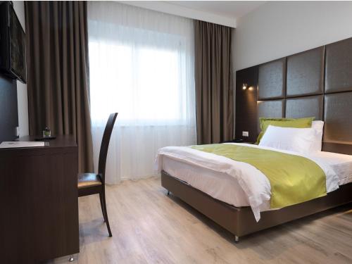a bedroom with a large bed and a television at Boutique Hotel Bellevue Rheinfelden / Basel in Rheinfelden