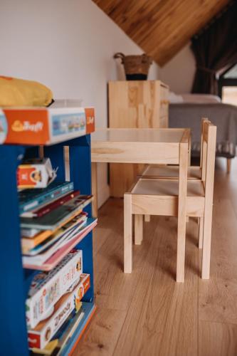 a wooden table and chair in a room with books at Lasosfera Lasówka in Lasowka