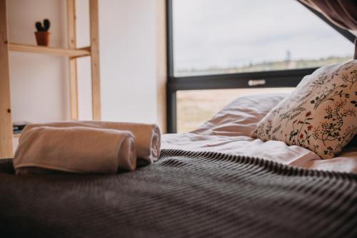 a bed with two towels on it with a window at Lasosfera Lasówka in Lasowka