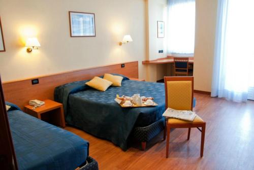 una camera d'albergo con un letto e un vassoio di cibo sopra di Hotel Touring a Falconara Marittima
