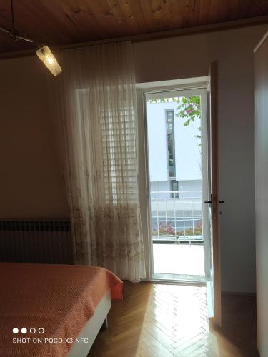 a bedroom with a bed and a large window at Villa Radić in Makarska