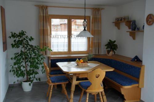 a dining room with a table and a blue bench at Ferienwohnungen Ellen Müller in Fischen