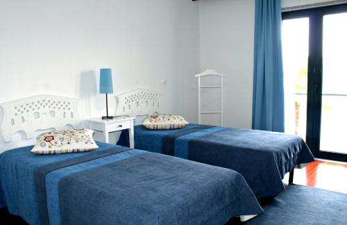 two blue beds in a room with a window at HI Alijo - Pousada de Juventude in Alijó