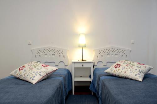a room with two beds and a lamp on a table at HI Alijo - Pousada de Juventude in Alijó