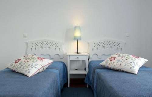 a bedroom with two beds and a lamp on a table at HI Alijo - Pousada de Juventude in Alijó