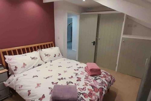 ein Schlafzimmer mit einem Bett mit rosa Kissen darauf in der Unterkunft Willow Cottage Cosy Cornish Rural Retreat - Dog Friendly Cornwall in Ponsanooth