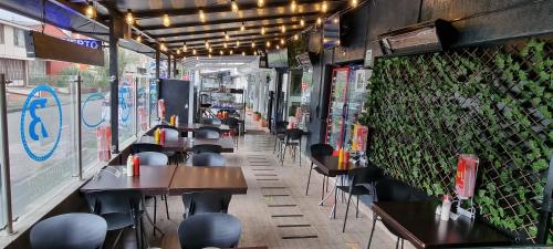 a restaurant with tables and chairs and a green wall at Blue House Corferias in Bogotá