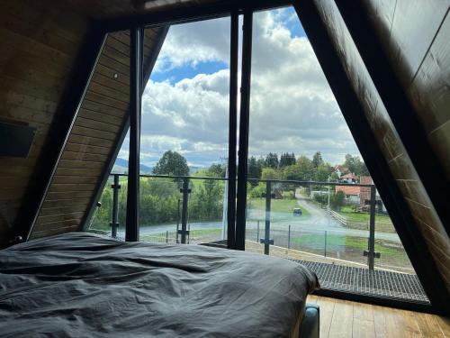 Bett in einem Zimmer mit einem großen Fenster in der Unterkunft V house Goc 