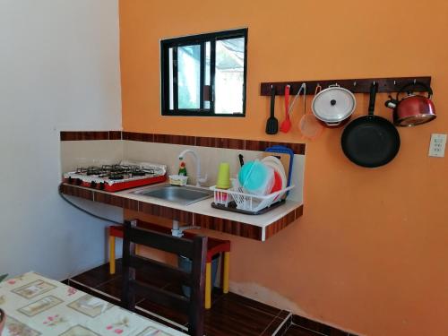 een kleine keuken met een wastafel en een aanrecht bij Casita Esmeralda in El Cuyo