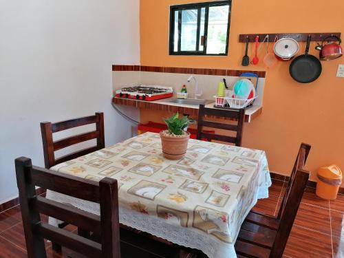 een keuken met een tafel met een tafelkleed erop bij Casita Esmeralda in El Cuyo