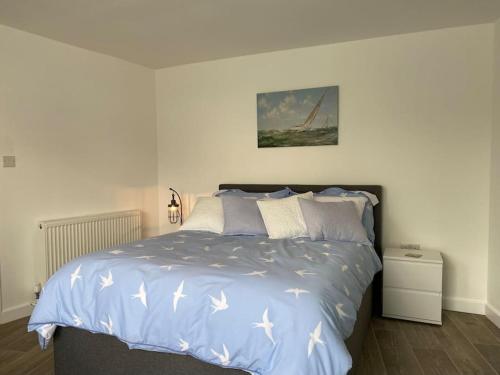a bedroom with a large bed with white sheets at Lovely 1 bed flat 200 metres from beach in Walton-on-the-Naze