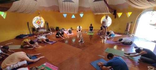 grupa ludzi robiących jogę w pokoju w obiekcie Espaço Cultural Lotus - Suítes, Hostel e Camping w mieście Alto Paraíso de Goiás