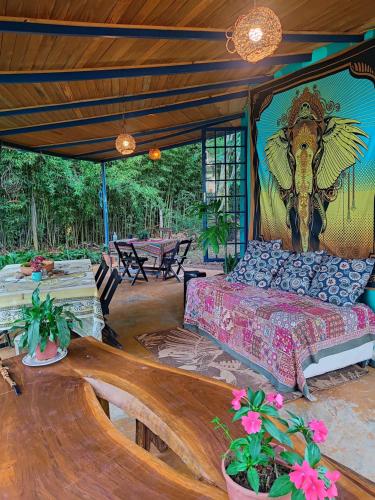 una habitación con una cama con una pintura de un toro en Espaço Cultural Lotus - Suítes, Hostel e Camping, en Alto Paraíso de Goiás