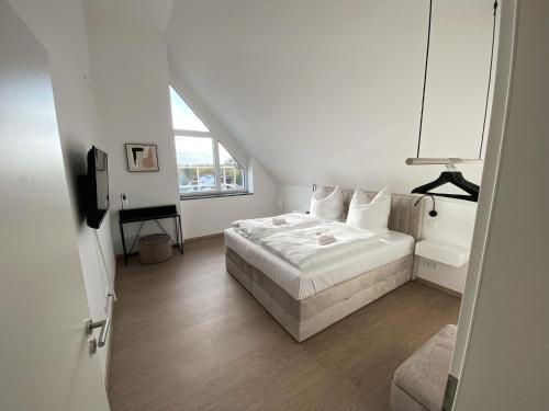 a white bedroom with a bed and a window at OASIS: Close to Munich - 4 Bedrooms - Kitchen in Dachau