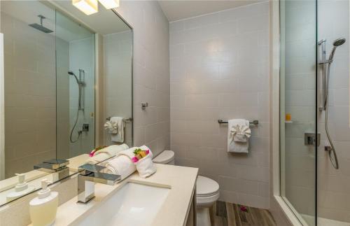 a bathroom with a sink and a toilet and a mirror at Sea Esta Studio I - Ideal for Couples! in Turtle Cove