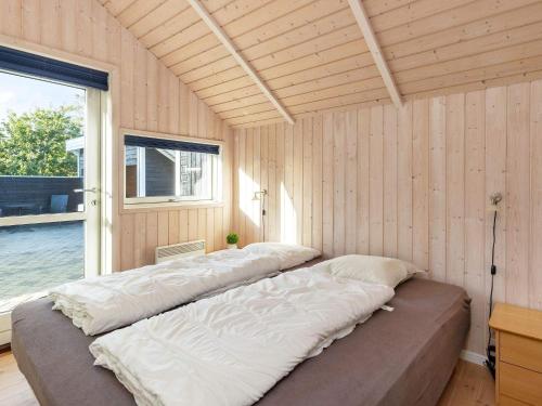 two beds in a room with a large window at Holiday Home Marionsvej in Trend