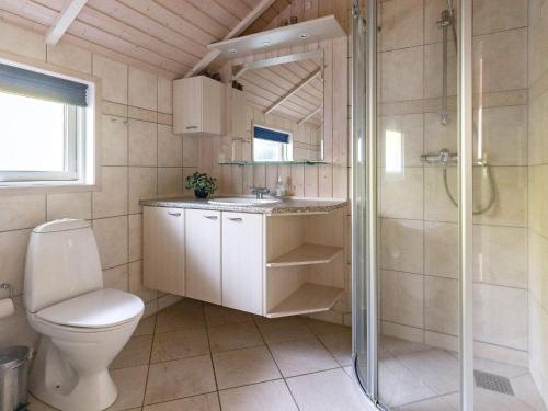 a bathroom with a toilet and a shower and a sink at Holiday Home Marionsvej in Trend
