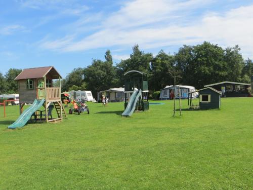 a park with a playground with slides and play structures at Boerderijcamping Plantlust in Veere