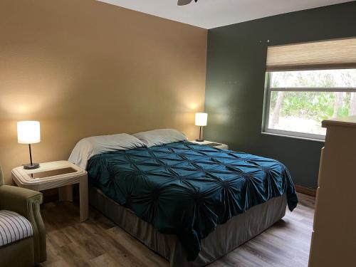 een slaapkamer met een bed, 2 lampen en een raam bij Hudson Home in Bayonet Point