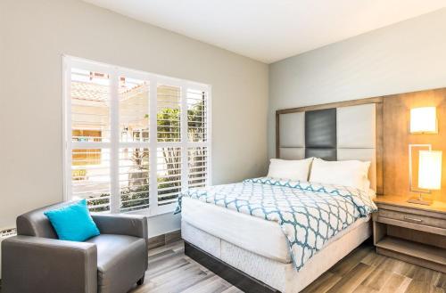 a bedroom with a bed and a chair and a window at Sea Esta Studio III - Cozy for Couples! in Turtle Cove