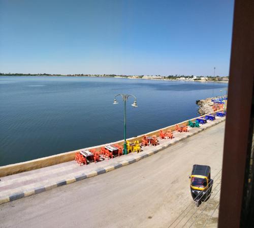 a group of cars parked next to a body of water at الضيافة in Shakshuk