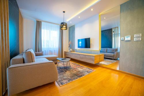 ein Wohnzimmer mit einem Sofa und einem TV in der Unterkunft Mons apartment in Novi Sad