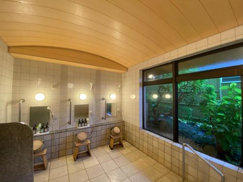 a bathroom with two toilets and a large window at Gora Onsen Kinkaku 金閣莊 預約制免費個人湯屋 Private onsen free by Reservation in Hakone