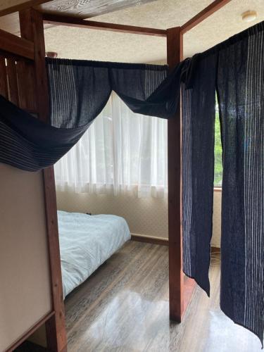 a bedroom with a bunk bed with blue curtains at 金閣莊 private onsen by reservation for free in Hakone