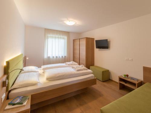 ヴァルダーオラにあるAppartement Gardenの大きなベッドとテレビのある寝室