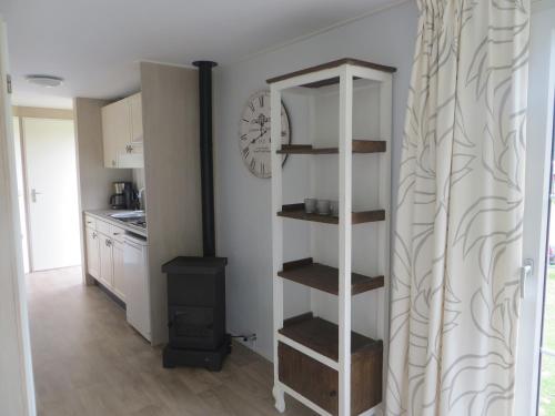 a kitchen with a book shelf in a room at Boerderijcamping Plantlust in Veere