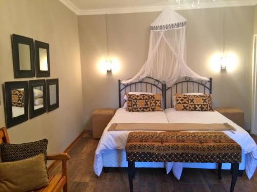 a bedroom with a bed with a canopy at Die Olyfhuis in Barkly West