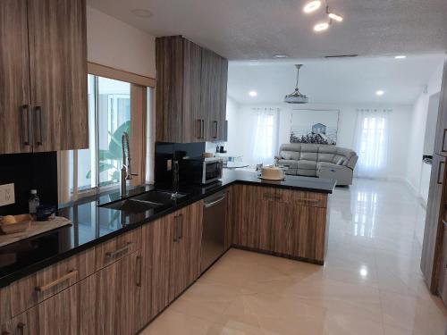 a kitchen with wooden cabinets and a living room at Cape Coral Mini Palace in Cape Coral