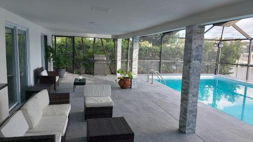 a house with a swimming pool with white furniture at Cape Coral Mini Palace in Cape Coral