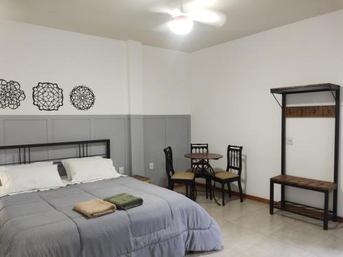 a bedroom with a bed and a table and chairs at Hostel Dom Bosco in São João del Rei