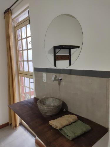 a bathroom with a bowl sink and a mirror at Hostel Dom Bosco in São João del Rei