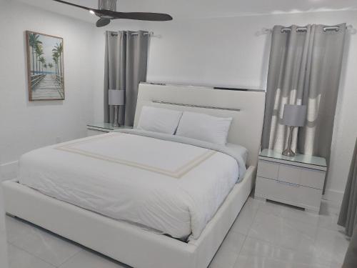 ein weißes Schlafzimmer mit einem weißen Bett und einer Decke in der Unterkunft Cape Coral Mini Palace in Cape Coral