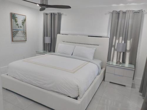 a white bedroom with a white bed and a ceiling at Cape Coral Mini Palace in Cape Coral