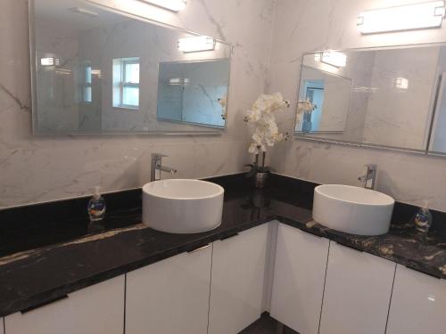 zwei Waschbecken im Bad mit zwei Spiegeln in der Unterkunft Cape Coral Mini Palace in Cape Coral