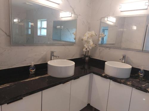 two sinks in a bathroom with two mirrors at Cape Coral Mini Palace in Cape Coral